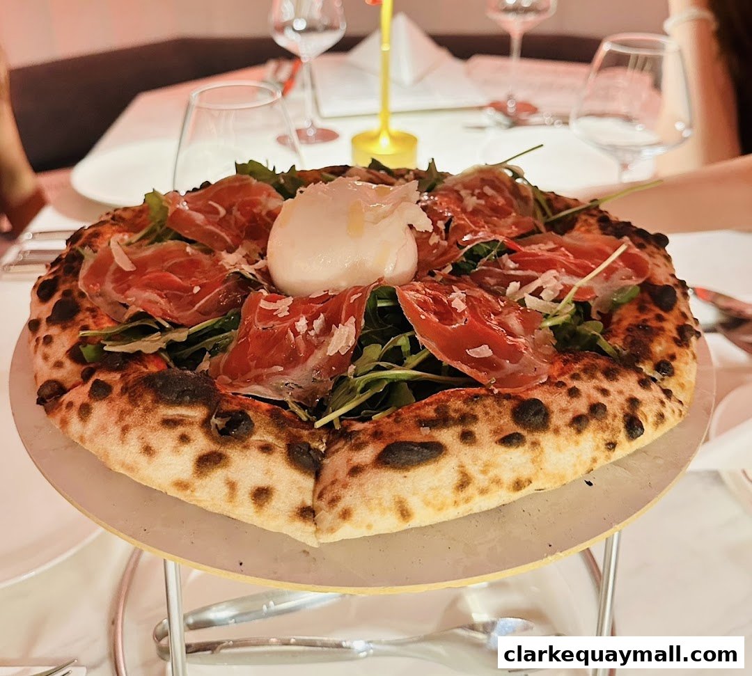 A delicious pizza topped with prosciutto, arugula, and burrata cheese, served at a restaurant.
