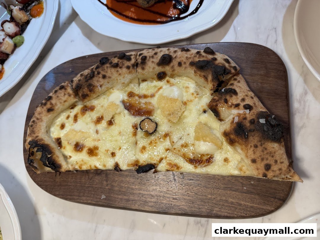 A delicious slice of white pizza with cheese and truffle on a wooden board.