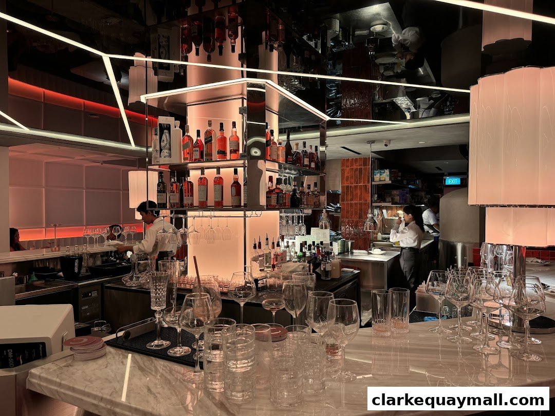 A stylish bar interior with bottles, glassware, and staff preparing drinks.