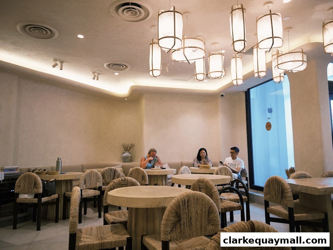 Interior of a modern cafe with natural light, unique pendant lights, and comfortable seating.