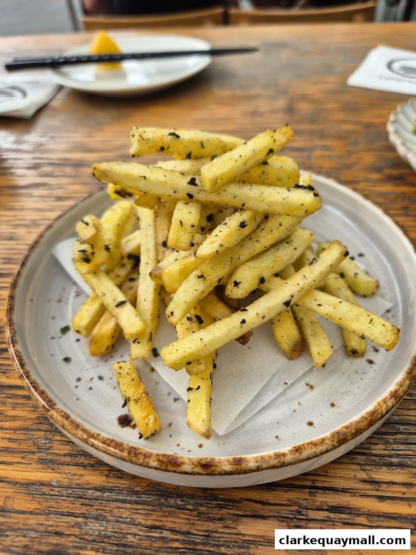 A close-up shot of a plate of seasoned french fries on a wooden table.