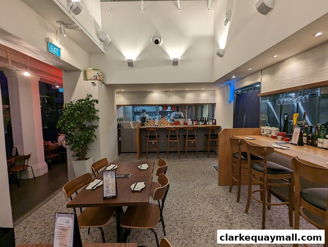 Interior view of a modern Japanese restaurant with dining tables and a bar.