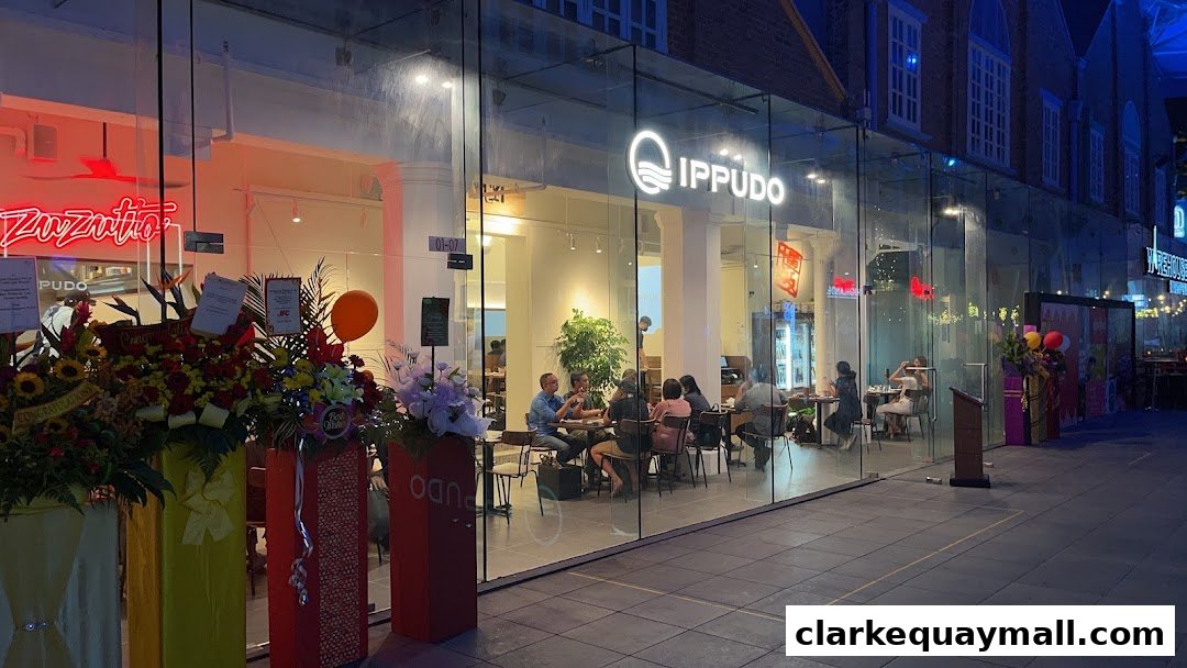 The exterior of the IPPUDO restaurant with a glass facade and people dining inside.