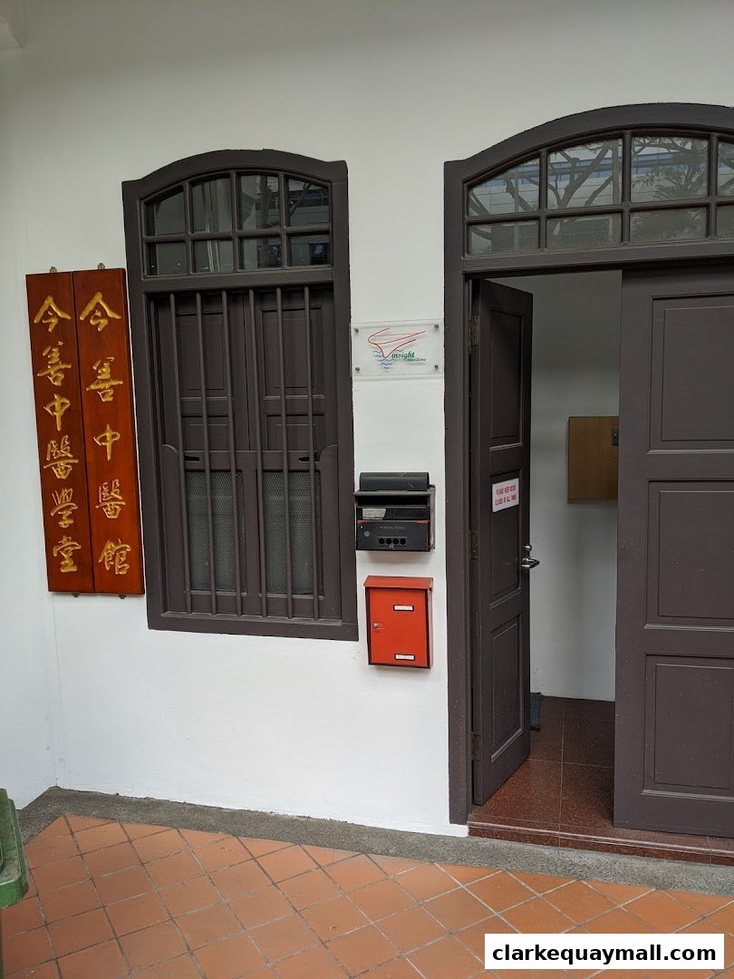 The entrance to J-Sun Health Management features traditional signage and dark wooden doors.