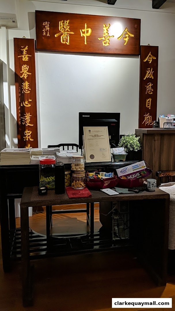 A desk area with a computer, certificates, and snacks, featuring traditional Chinese calligraphy.
