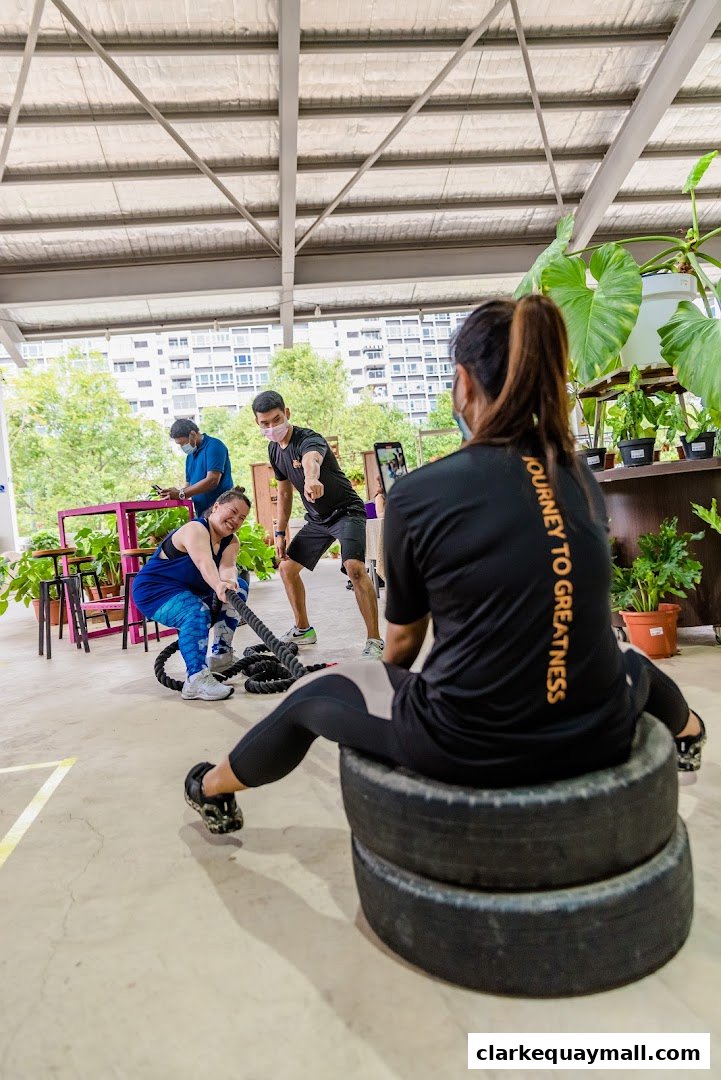 People training with ropes and tires in a gym setting.