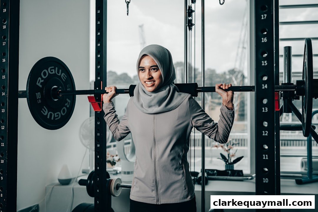 A woman in a hijab lifts weights at a gym.