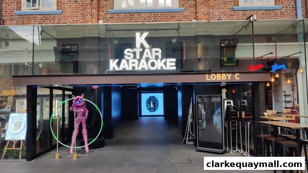 The entrance to K.STAR KARAOKE features a neon sign, a pink mascot, and a walkway leading inside.