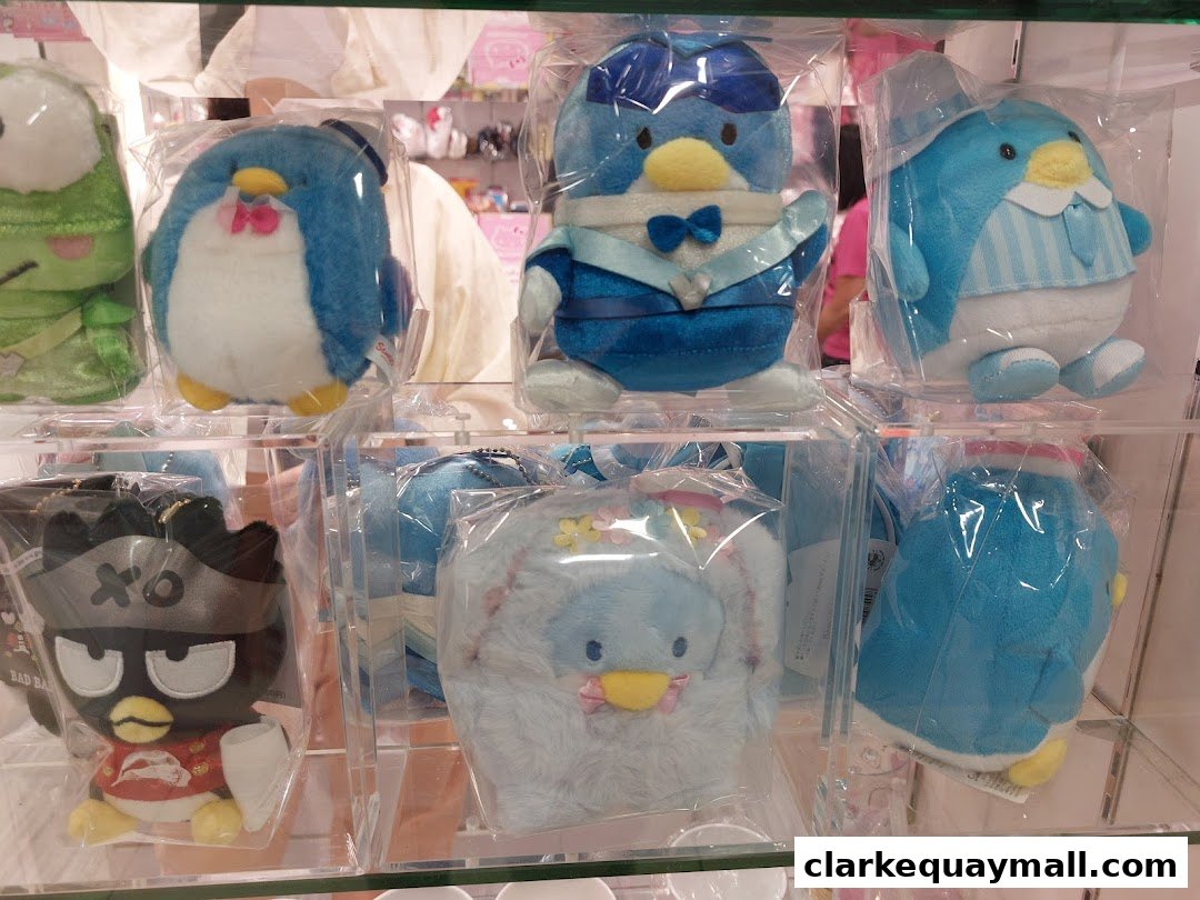 A display of various cute plush toys, mostly penguins, in clear packaging.