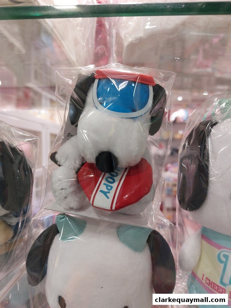 Close-up of cute plush toys, featuring dogs with sunglasses and hearts, displayed in plastic packaging.