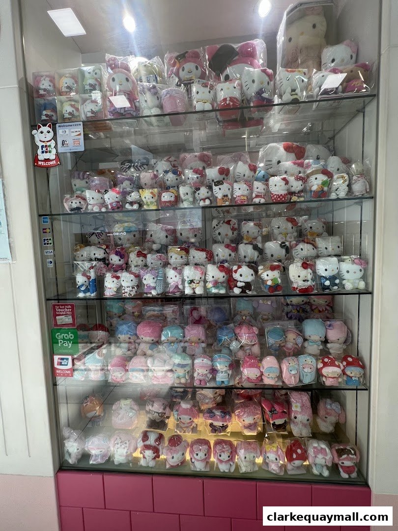 A display case filled with numerous Hello Kitty and other character plush toys and gifts.