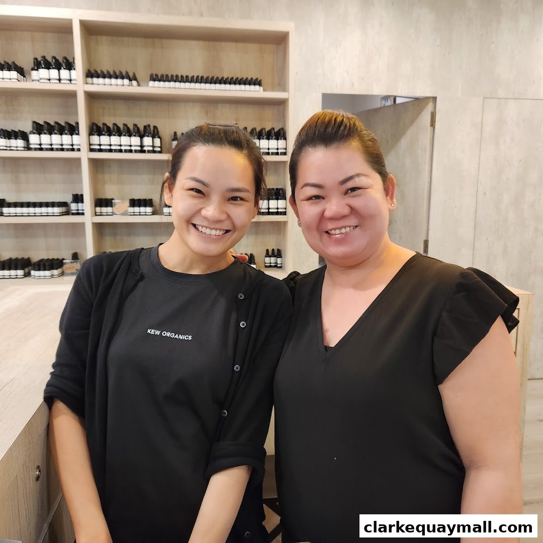Two smiling women stand in front of shelves stocked with organic skincare products.