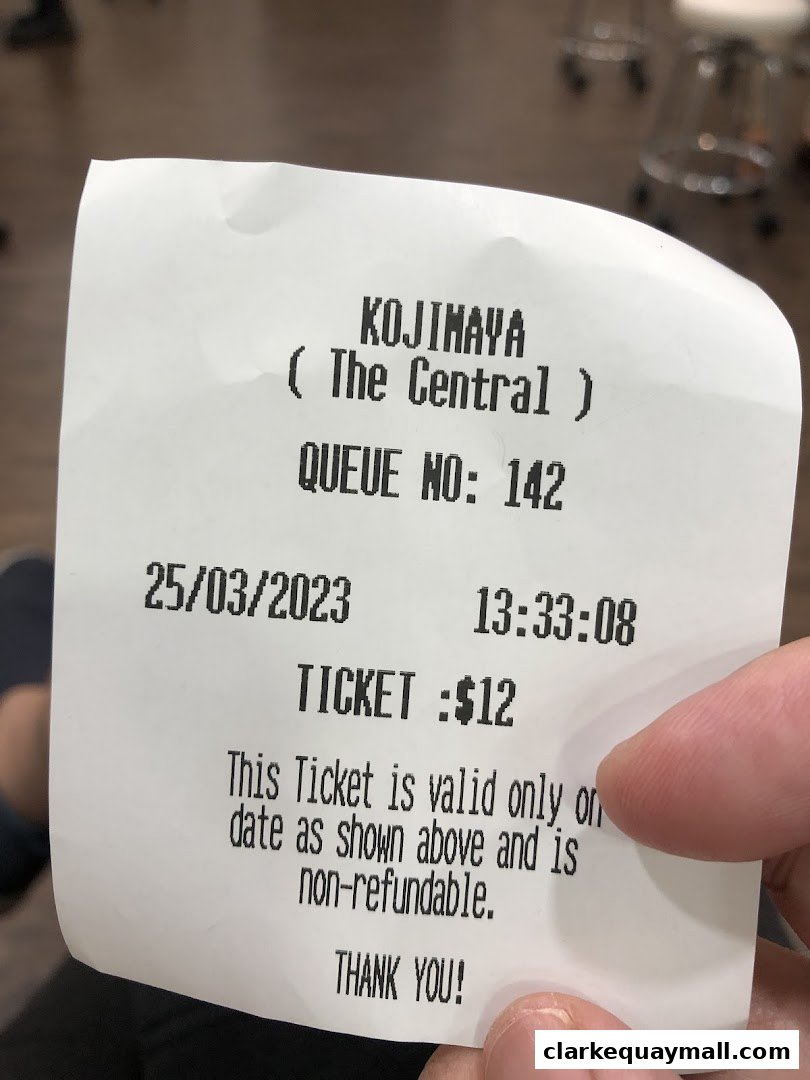 A receipt from KOJIMAYA showing a queue number and ticket price.