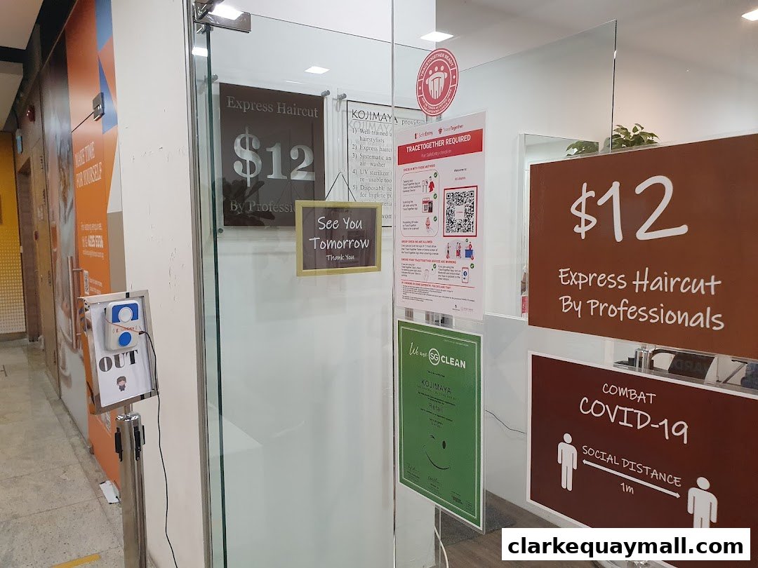 The entrance to KOJIMAYA hair salon, featuring an express haircut offer and COVID-19 safety measures.