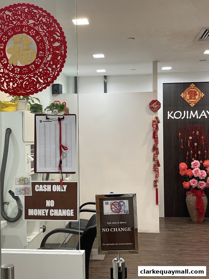 Shop entrance with 'KOJIMAYA' logo, cash only signs, and festive decorations.