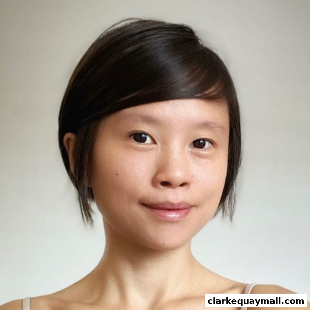 A close-up portrait of a young woman with short dark hair and a gentle smile.
