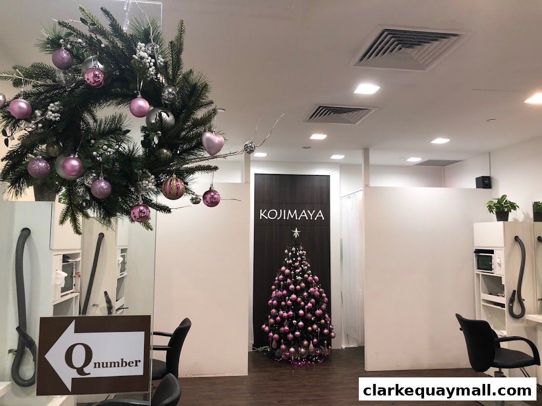 Interior of KOJIMAYA salon with Christmas decorations, including a wreath and tree.