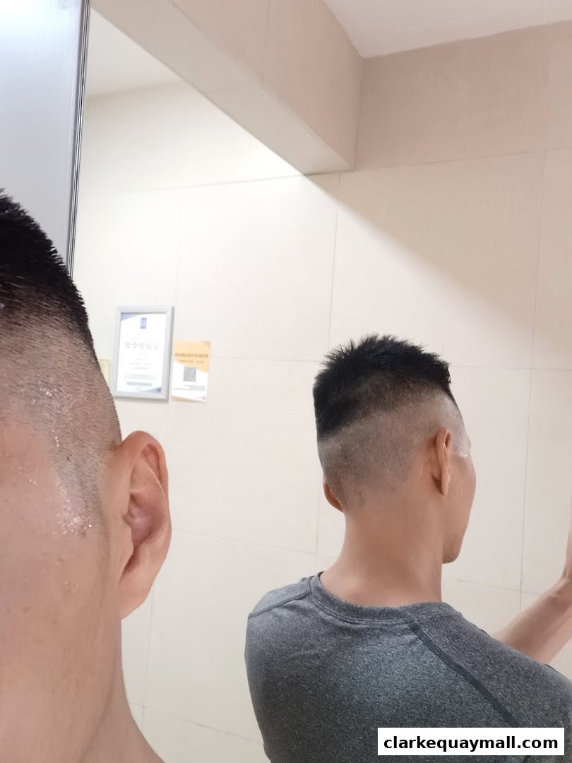 A person's head and ear reflected in a mirror, showing a fresh haircut.