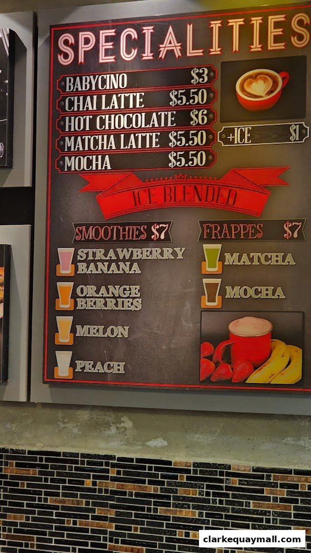 A menu board displaying specialties, smoothies, and frappes with prices.