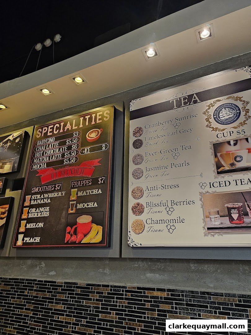 A menu board displaying specialty drinks, smoothies, frappes, and various teas.