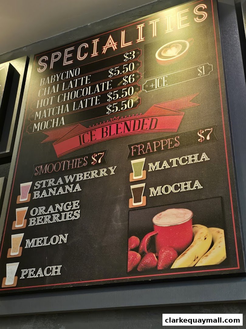 A menu board displays various specialty drinks, smoothies, and frappes with prices.