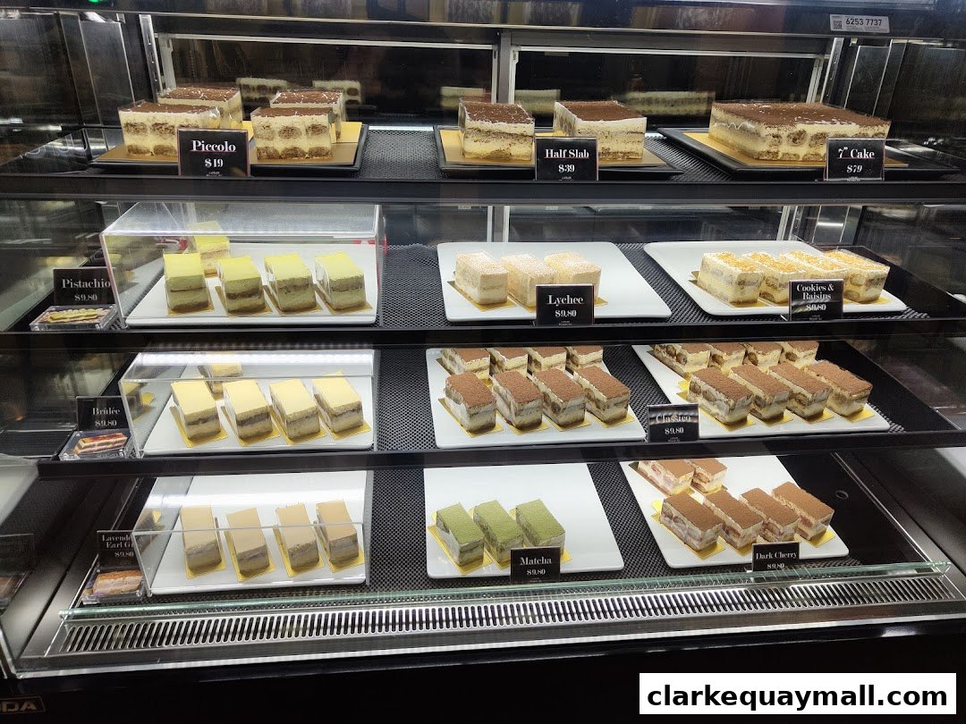 A display case filled with various flavors of tiramisu and other desserts.