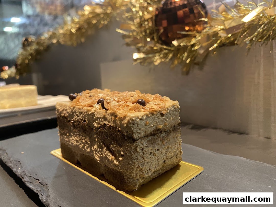 A slice of tiramisu cake with coffee-flavored cream and chocolate chips.
