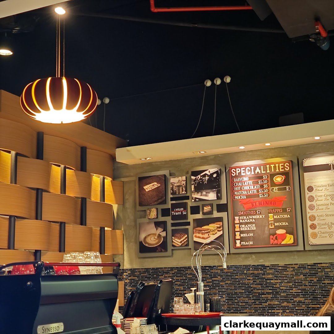 Interior of L'Atelier Tiramisù cafe with a stylish wooden wall and a menu board.