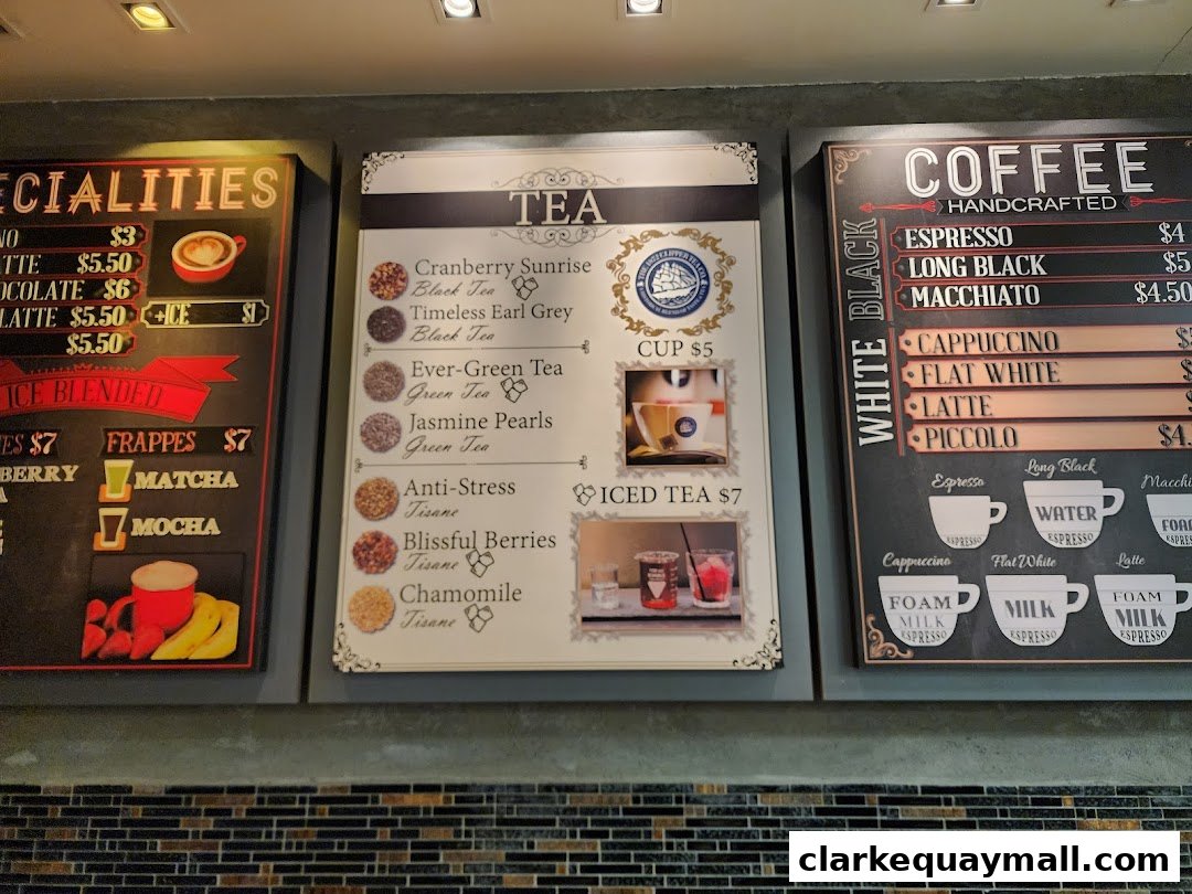 A menu board displaying coffee, tea, and specialty drink options with prices.