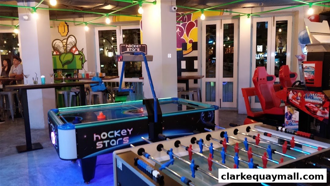 Interior of a lively arcade bar with air hockey, foosball, and racing games.