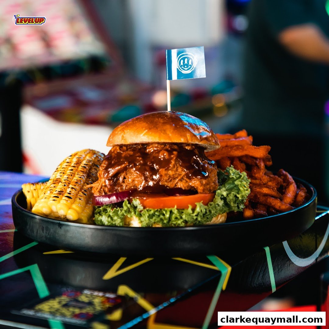A juicy pulled pork burger with corn on the cob and sweet potato fries.