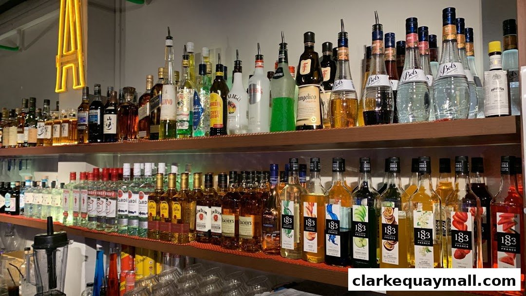 A well-stocked bar with shelves full of various liquor bottles and syrups.
