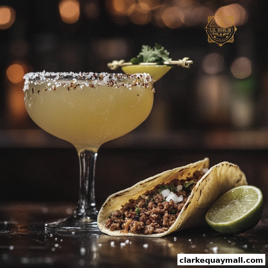 A cocktail and a taco are displayed on a dark surface with a lime wedge and salt.