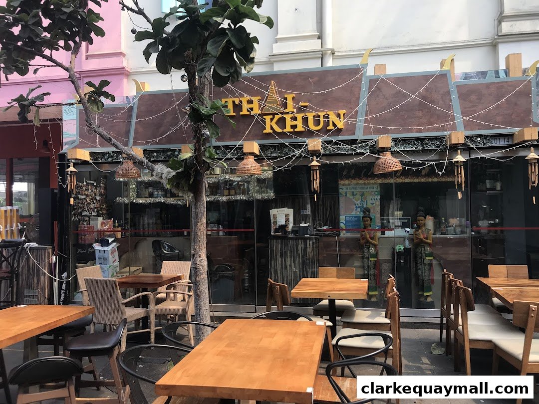 The exterior of a Thai restaurant with outdoor seating and decorative lights.