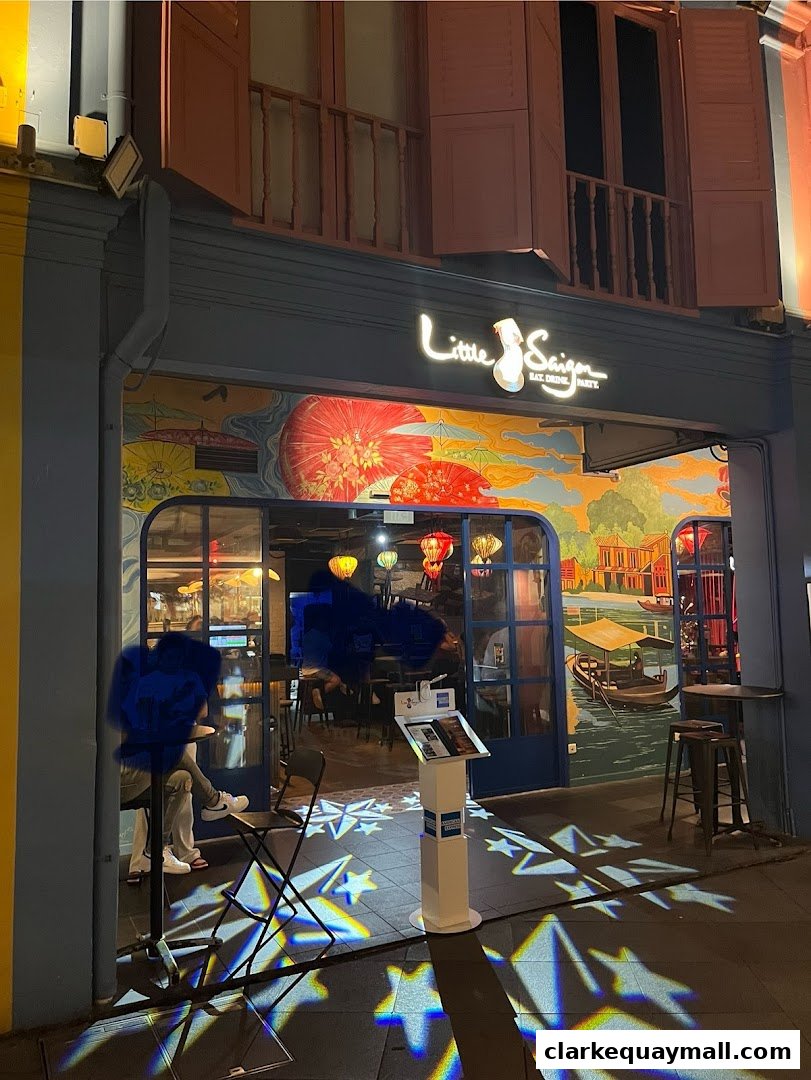The exterior of Little Saigon restaurant with vibrant murals and illuminated signage.