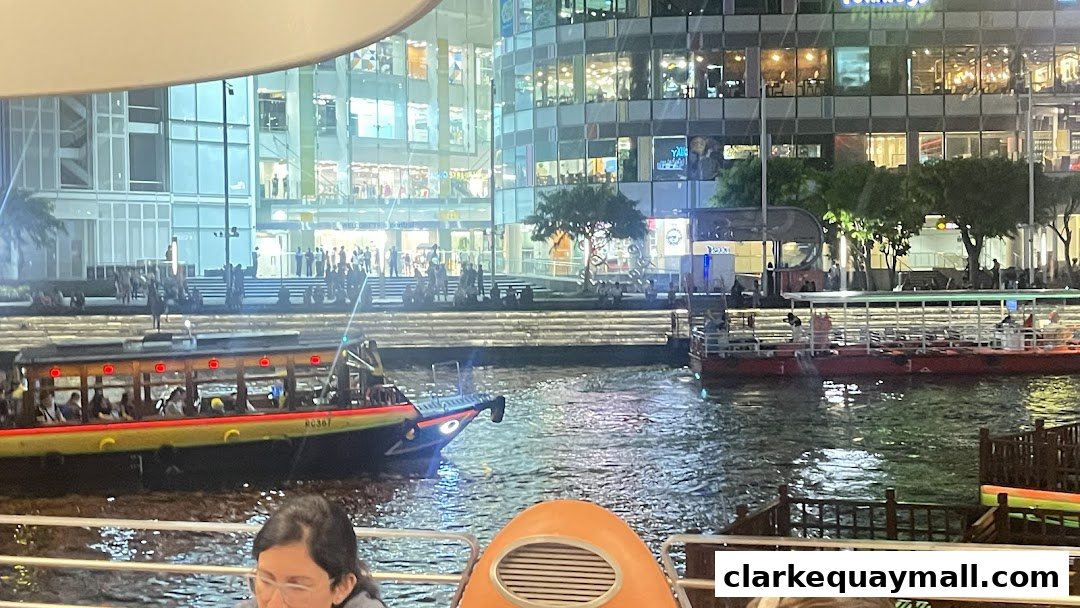 A scenic evening view of a river with boats and illuminated buildings.