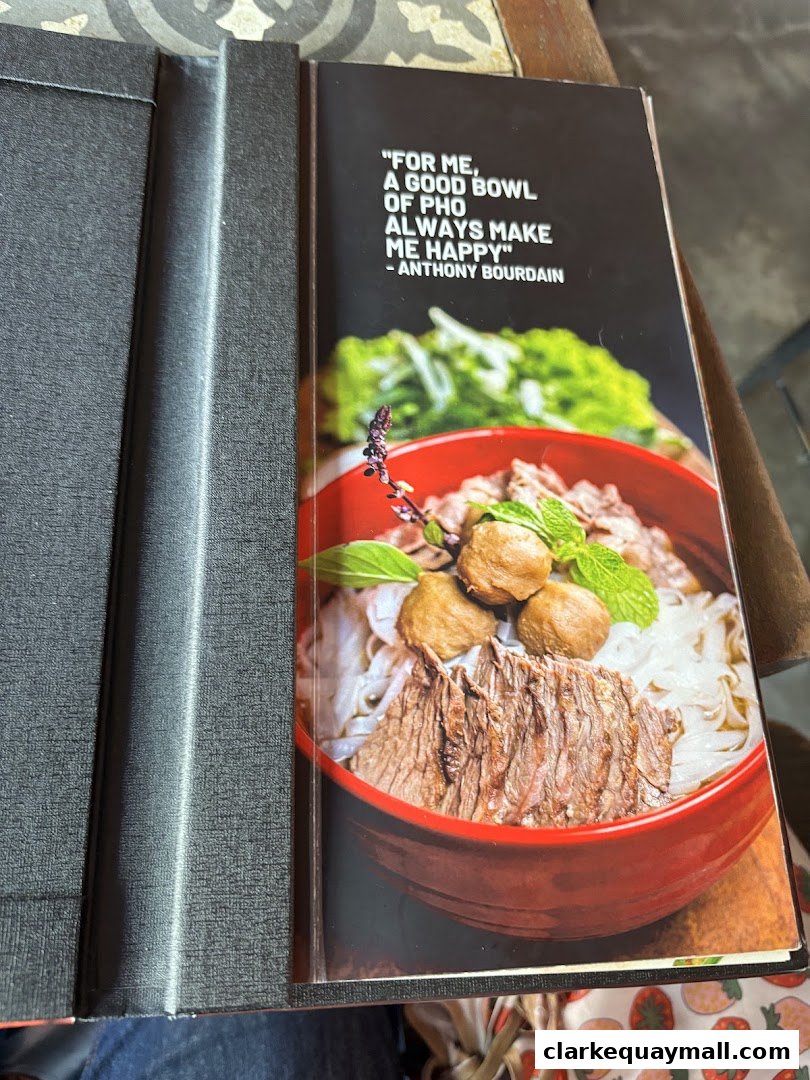 A menu cover featuring a quote about pho and a close-up of a pho bowl.