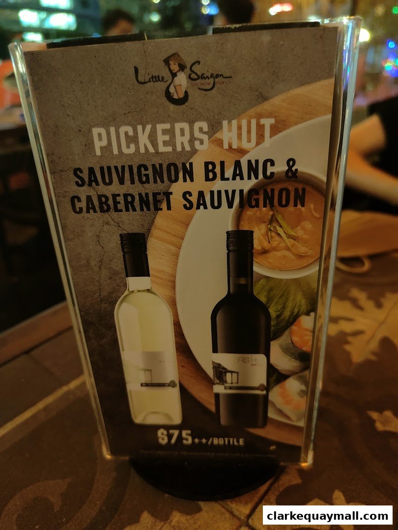 A menu display for Little Saigon featuring wine bottles and food.