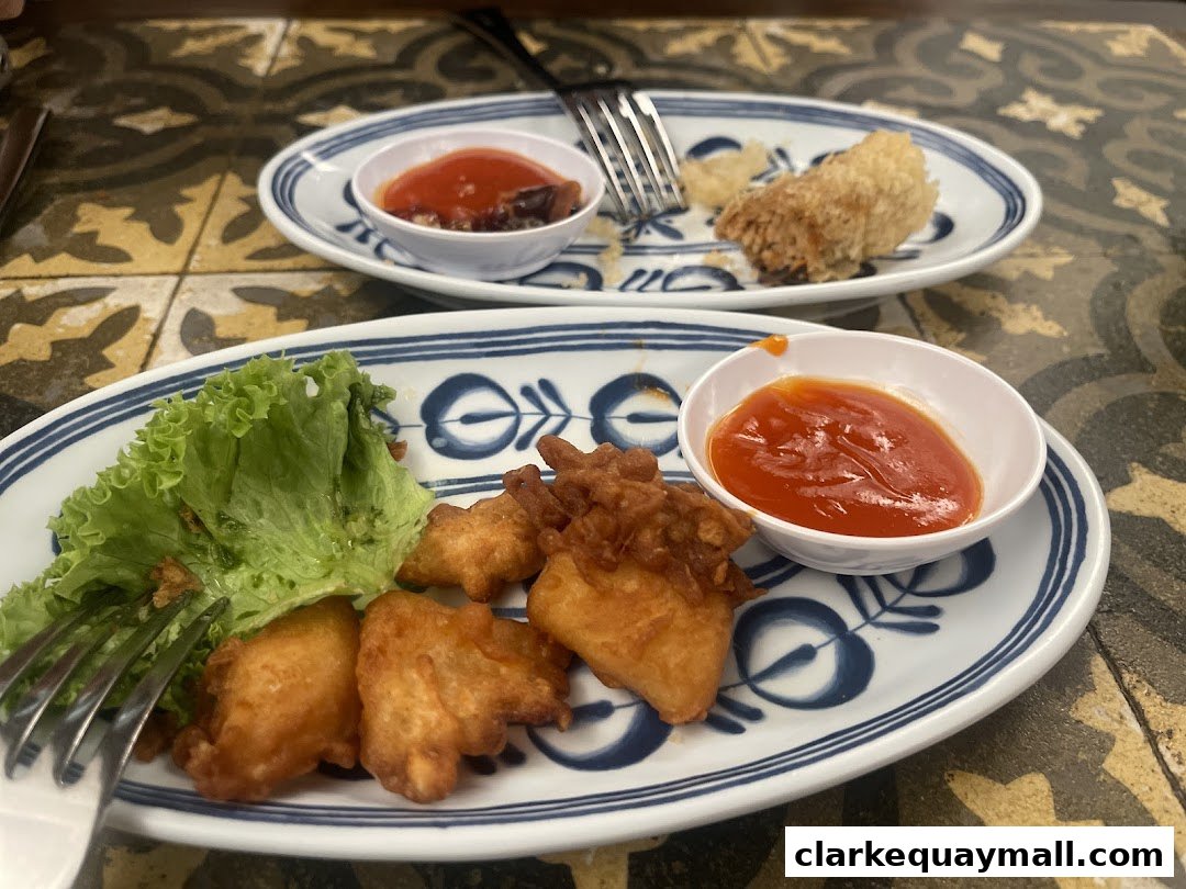 Two plates of fried food with dipping sauce and lettuce on a patterned table.