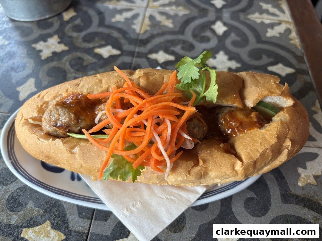 A delicious Vietnamese Banh Mi sandwich filled with meat, pickled carrots, and cilantro.