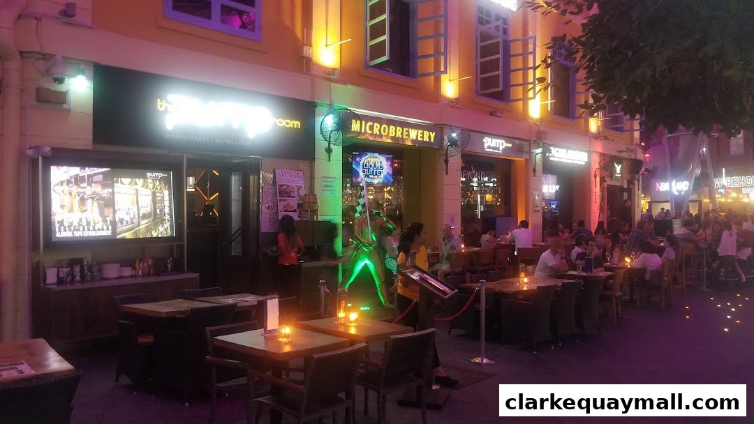 A lively street scene with multiple bars and restaurants, featuring outdoor seating and neon lights.