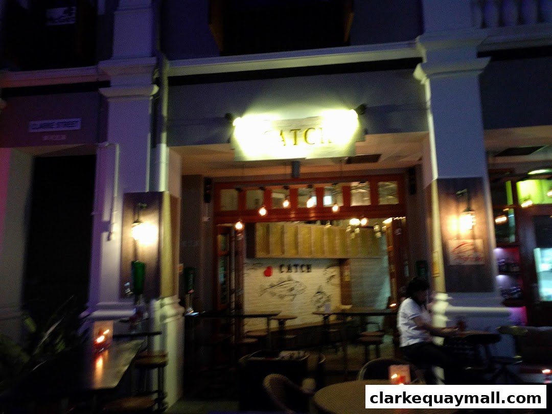 The illuminated entrance of a bar or restaurant named 'Catch' at night.