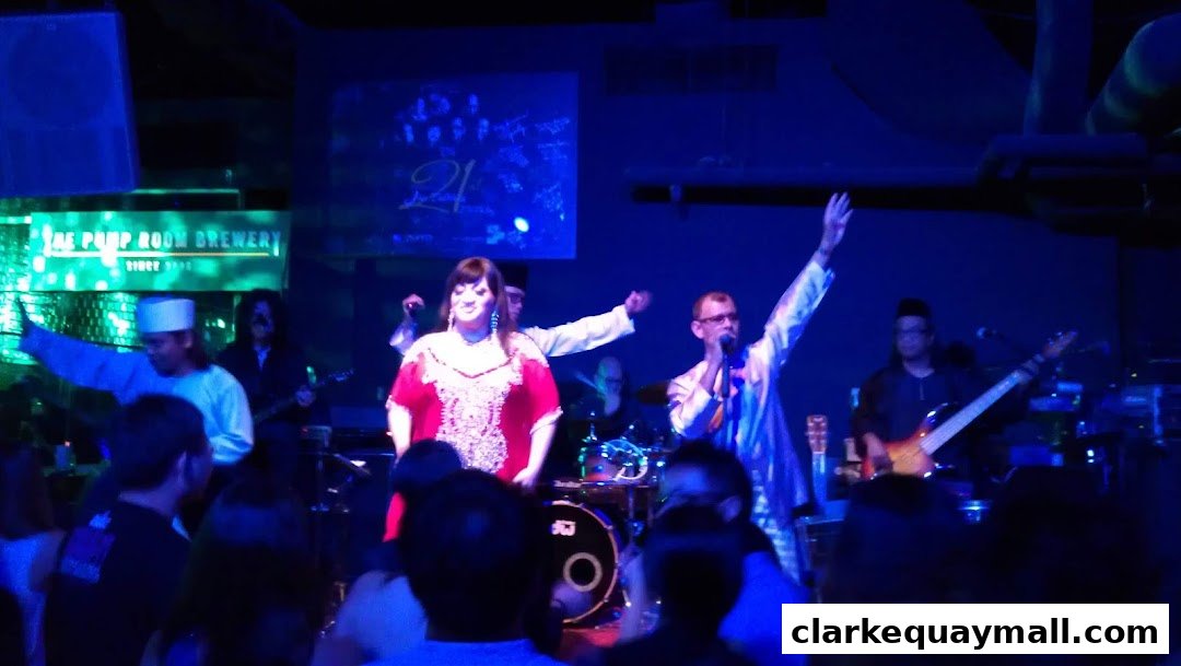 A live band performs on stage at The Pump Room Brewery, with a crowd watching.