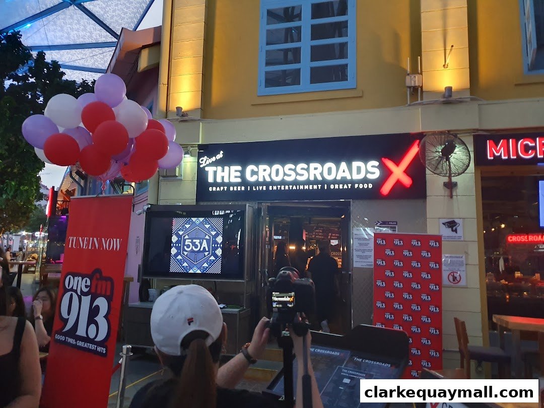 The entrance of 'The Crossroads' bar with balloons and promotional banners outside.