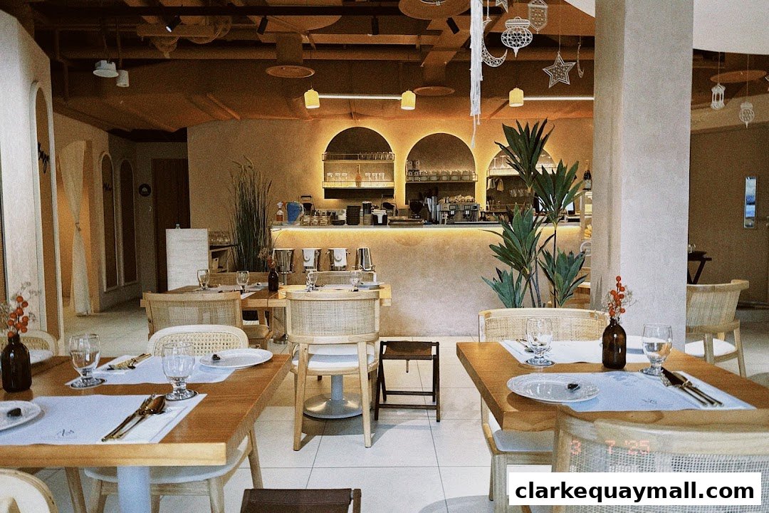 Interior of a restaurant with tables set for dining and a bar area in the background.