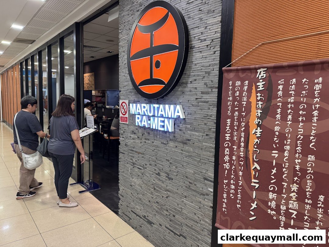 The entrance of Marutama Ramen with a prominent sign and a promotional banner.