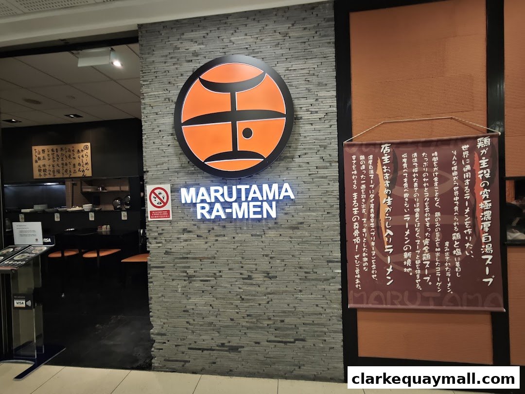 The entrance of Marutama Ramen, featuring its logo, name, and a promotional banner.