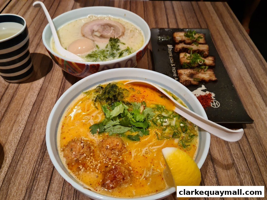 Two bowls of ramen and a plate of chashu pork are displayed on a wooden table.