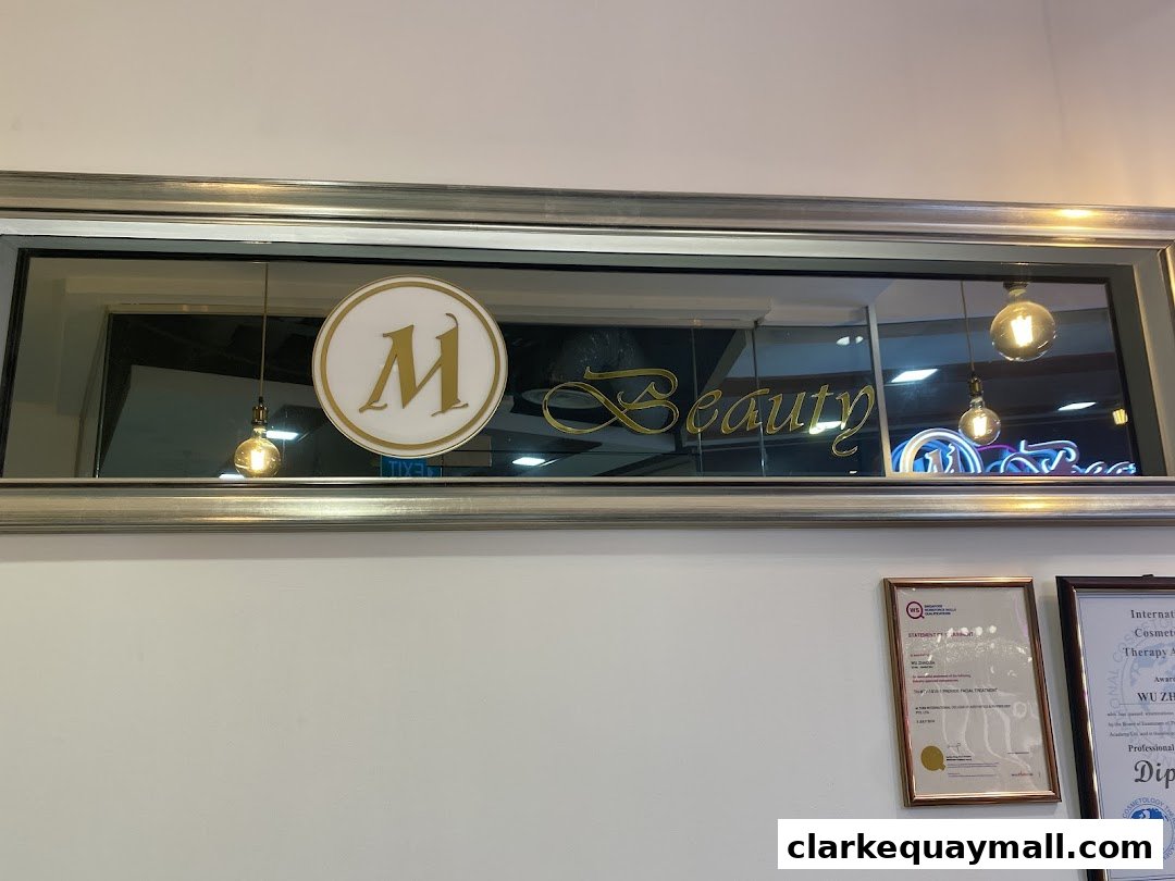 The shop front sign for Mega Beauty, featuring a large 'M' logo and elegant script.