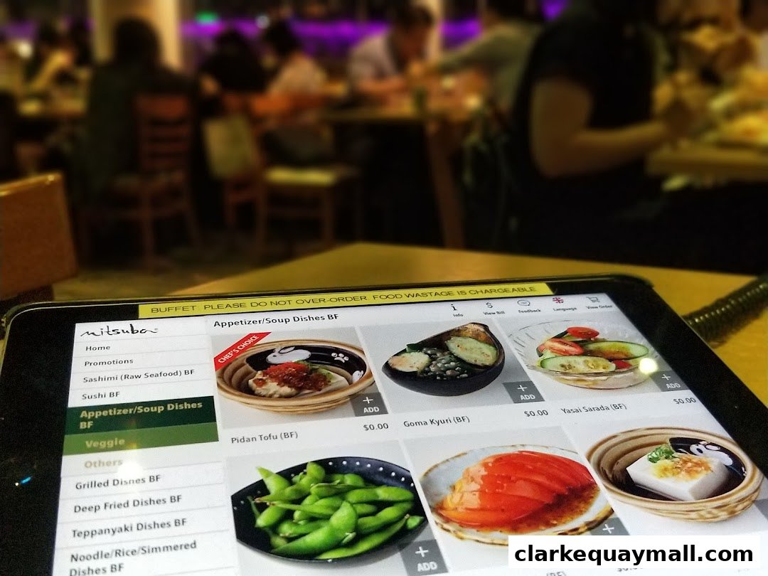 A tablet displays a Japanese restaurant's menu with various dishes and prices.